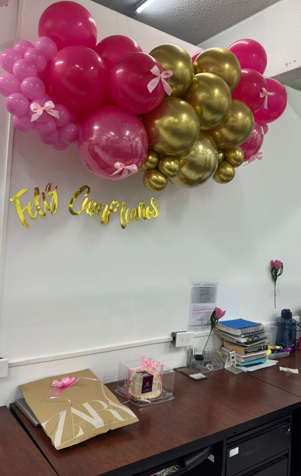 Guirnalda Feliz Cumpleaños rosa y dorado armada en la oficina